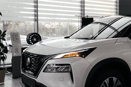 Rear part of new modern white car parked at showroom. Exterior of electric car waiting for sale to customer in light dealership. Car for rent business concept. Automobile leasing and insurance photo