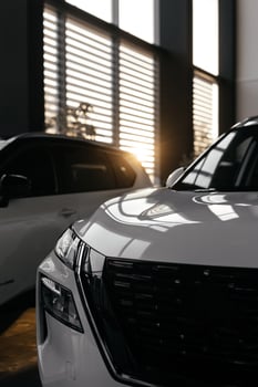 Rear part of new modern white car parked at showroom. Exterior of electric car waiting for sale to customer in light dealership. Car for rent business concept. Automobile leasing and insurance photo