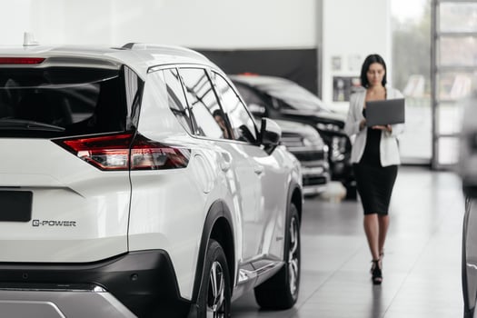 Rear part of new modern white car parked at showroom. Exterior of electric car waiting for sale to customer in light dealership. Car for rent business concept. Automobile leasing and insurance photo
