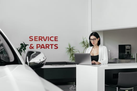 Sales woman use smartphone, have business call at car showroom. Car dealership client service and parts. Business Process and Problem Solving, Quality Control. Cell phone advise to choose, buy auto photo
