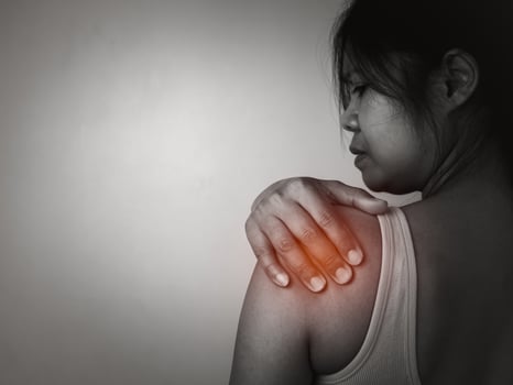Woman with acute pain shoulder with neck pain on gray background, Shoulder inflammation and arm, Female massaging her shoulder muscle spasm, Healthcare and medical concept, Injuries and medical. photo