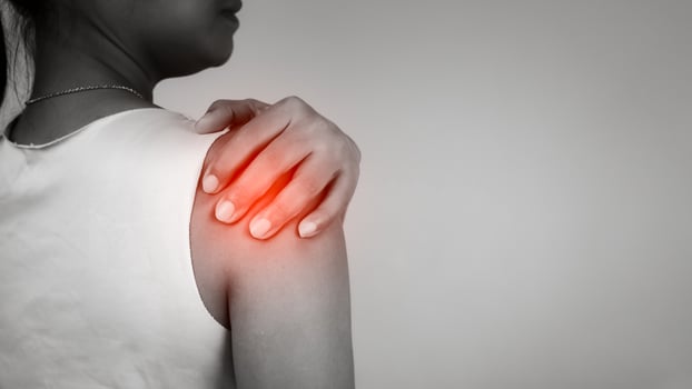 Woman with acute pain shoulder with neck pain on gray background, Shoulder inflammation and arm, Female massaging her shoulder muscle spasm, Healthcare and medical concept, Injuries and medical. photo