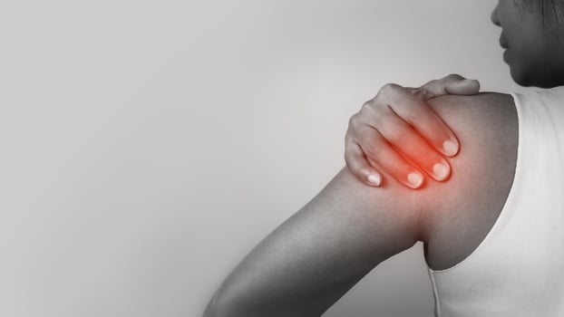 Woman with acute pain shoulder with neck pain on gray background, Shoulder inflammation and arm, Female massaging her shoulder muscle spasm, Healthcare and medical concept, Injuries and medical. photo