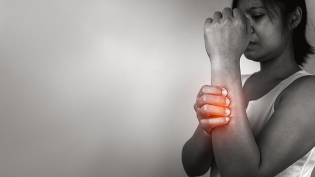 Woman with acute pain elbow with arm pain on gray background, Elbow and arm treatment, Female massaging her elbow muscle spasm, Healthcare and medical concept, Injuries and medical concept. photo