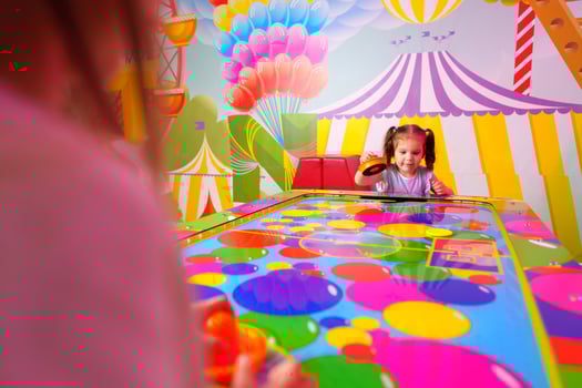 Young Girl Engaging in Colorful Board Game Fun at a Vibrant Playroom photo