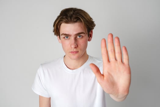 Young Man in White T-Shirt Showing Stop Gesture With Hand photo