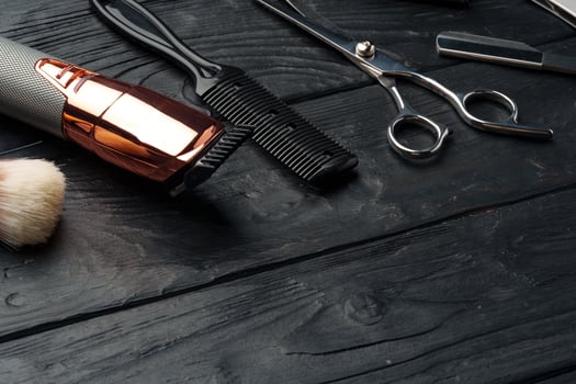 Professional Barber Tools Laid Out on Dark Wooden Surface photo