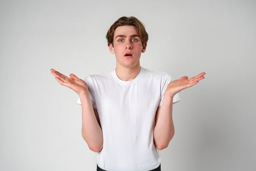 Young Man With Surprised Expression and Hands Raised in Studio Setting photo