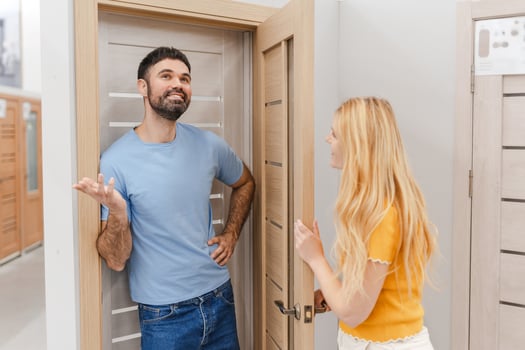 Smiling man and woman buying interior door while standing in the hardware store photo
