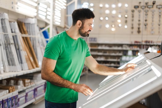 Happy young male consumer buying window frame in hardware store. Shopping concept photo