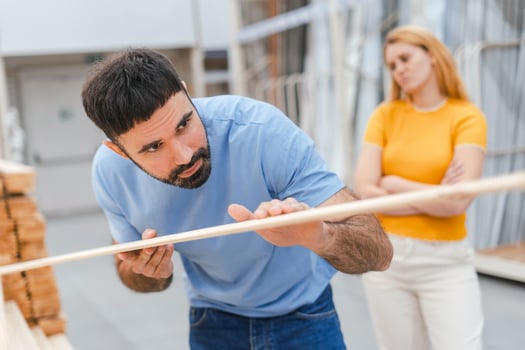 Young man and woman choosing plywood and boards in construction store photo