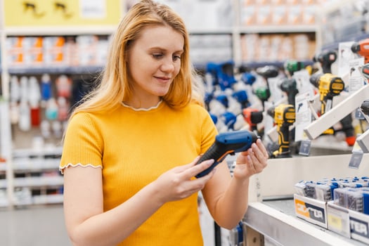 Woman holding driller in the store. Hardware construction site objects concept photo