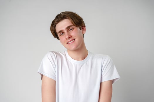 Young Man in White T-Shirt Smiles at Camera photo
