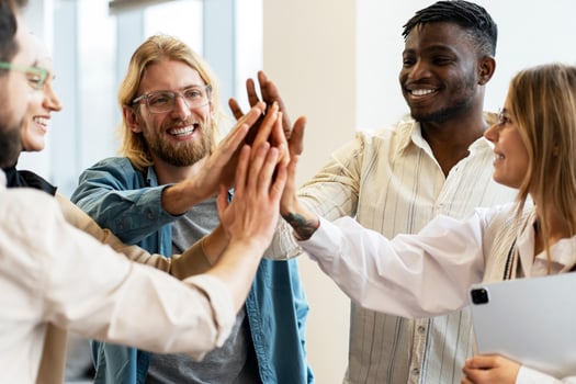 Diverse team of professionals giving high five and celebrating success photo