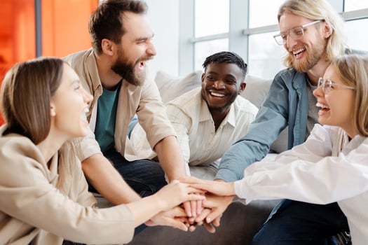 Group of diverse people joining hands together smiling and laughing photo
