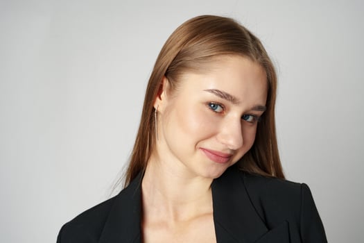 Young Woman in Black Jacket Posing to Camera against gray background photo
