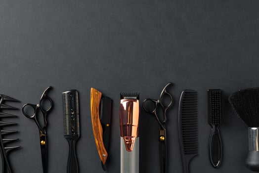 An Assortment of Professional Hairdressing Tools Laid Out on a Dark Surface photo