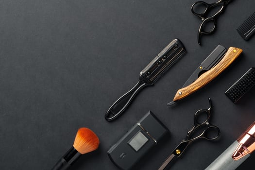 An Assortment of Professional Hairdressing Tools Laid Out on a Dark Surface photo