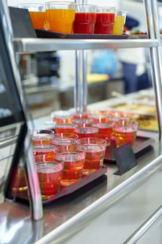 Colorful Array of Fruit Juice Cups on a Serving Cart in a Cafeteria photo