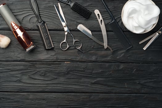 Professional Barber Tools Laid Out on Dark Wooden Surface photo
