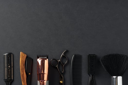 An Assortment of Professional Hairdressing Tools Laid Out on a Dark Surface photo