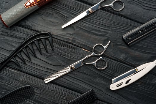 Professional Barber Tools Laid Out on Dark Wooden Surface photo