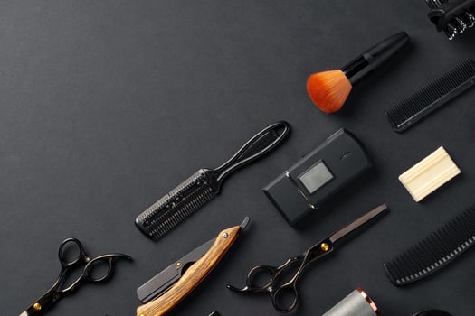 An Assortment of Professional Hairdressing Tools Laid Out on a Dark Surface photo