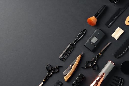 An Assortment of Professional Hairdressing Tools Laid Out on a Dark Surface photo