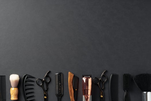 An Assortment of Professional Hairdressing Tools Laid Out on a Dark Surface photo