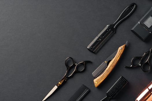 An Assortment of Professional Hairdressing Tools Laid Out on a Dark Surface photo