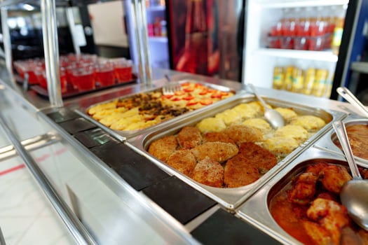 Bustling Cafeteria Serving Line During Lunchtime Offering a Variety of Dishes photo