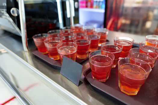 Colorful Array of Fruit Juice Cups on a Serving Cart in a Cafeteria photo