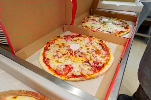 Two Freshly Baked Pizzas in Open Cardboard Boxes Ready for Delivery photo