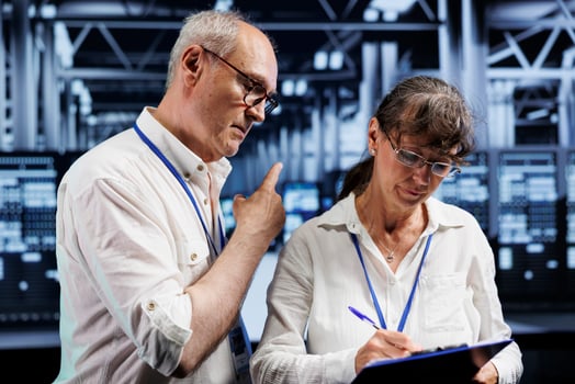 Aged wiremen brainstorming ways to repair server farm components. Skilled electricians brainstorming ideas on how to best minimize high tech facility downtime and prevent data loss photo