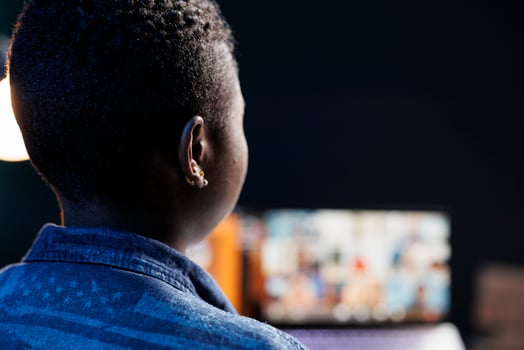 Over the shoulder shot of african american female freelancer engaged in a virtual meeting with clients on laptop. Black woman looking at laptop screen and listening to call. photo