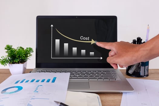 Hand pointing to laptop screen to show graph of cost reduction. Cost reduction analysis in the workplace. photo