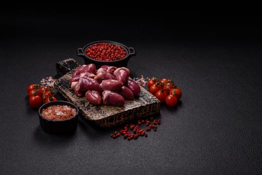 Raw chicken hearts with salt, spices and herbs photo
