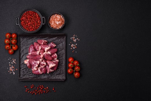 Raw chicken hearts with salt, spices and herbs photo