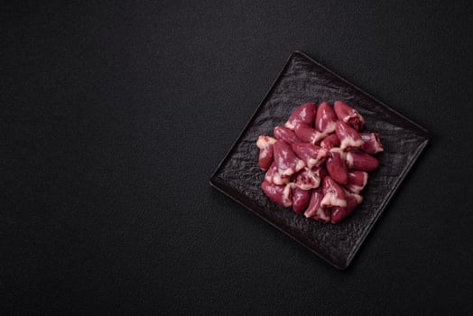 Raw chicken hearts with salt, spices and herbs photo