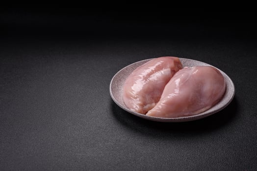 Pieces of raw chicken or turkey fillet with salt, spices and herbs photo