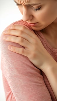 Woman Holding Her Shoulder in Pain Close Up White Background photo