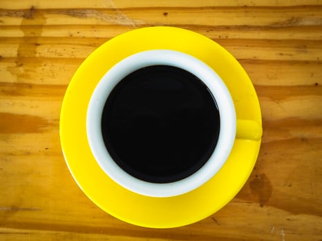 Single Yellow coffeecup put on wooden table. photo