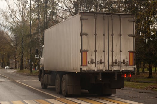 A truck is driving down the road. Freight. Roomy body. photo