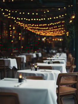 Cozy restaurant ambiance with empty tables and warm string lights at dusk photo