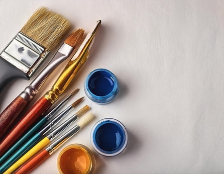 Paint and brushes lie on a white canvas. Creative Activities photo