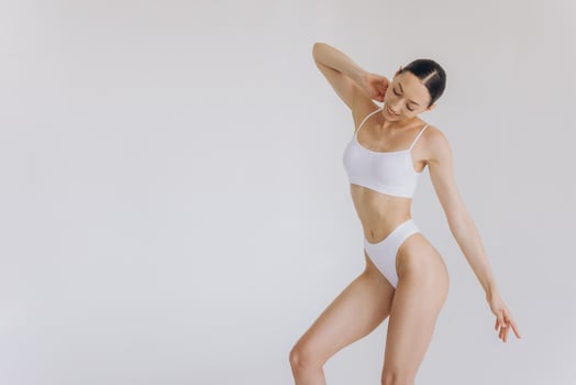 Portrait of beautiful woman with slim body in underwear posing in the white studio background with copy space, mock-up photo