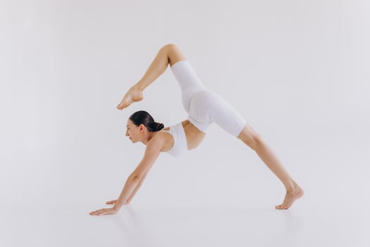 Sporty young woman with slim body doing yoga practice and stretching isolated on white background - concept of healthy life and natural balance between body and mental development photo