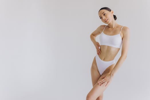 Close up view. Beautiful woman with slim body and perfect stomach in underwear posing in white studio background. photo