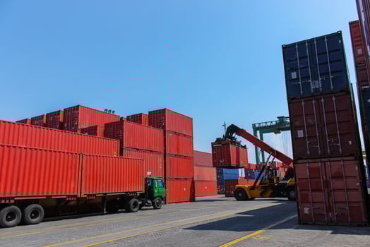 Industrial crane lift shipping cargo to from truck in commercial and export import harbor photo