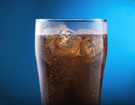Carbonated soda glass on blue background photo